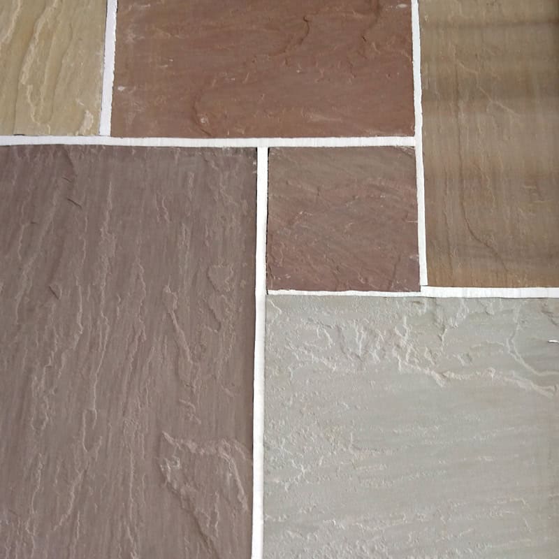 Close-up of a multicolored stone tile floor made from Strata 22mm Calibrated Sandstone CAMEL, featuring rectangular tiles in brown, beige, and gray. The geometric pattern is highlighted by visible white grout lines with precision-cut tiles at a 22mm depth.