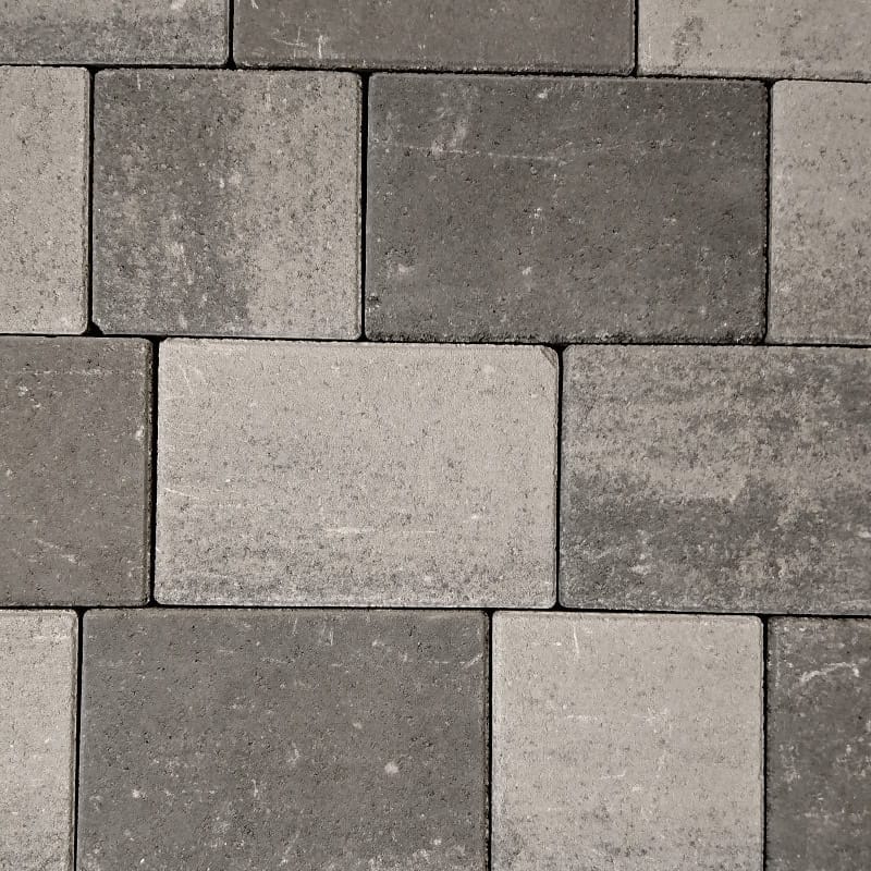 A close-up view of a brick wall featuring Barleystone 60mm Castlepave Smooth Ashblend rectangular bricks in gray shades, arranged in a staggered pattern for a textured and uniform appearance.