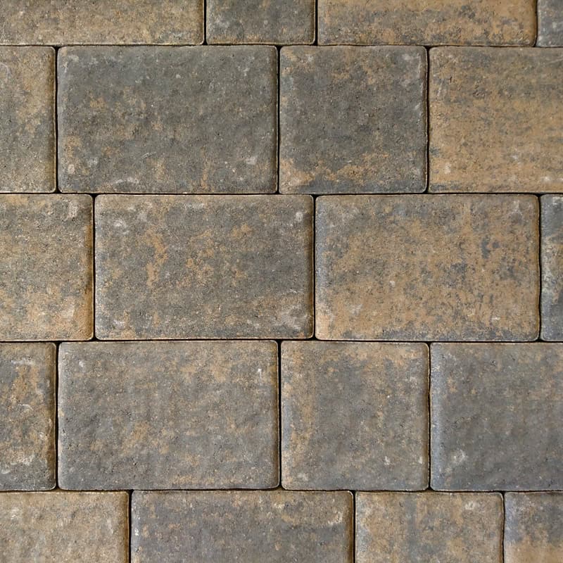 A close-up of a neatly arranged brick wall with Barleystone 50mm Ashford Autumn stones in varying shades of gray and brown, forming a pattern. The surface, captured with a 50mm lens, has a slightly rough and rustic appearance.