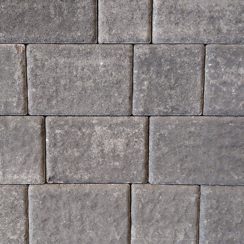 The Barleystone 50mm Ashford Silver Grey bricks create a flat, uniform surface with a rectangular pattern. They feature subtle texture and color variations, including speckles and wear, giving them a rustic look.