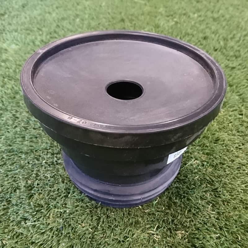 A 110mm Universal Drain Adaptor, black and round, is situated atop artificial grass.