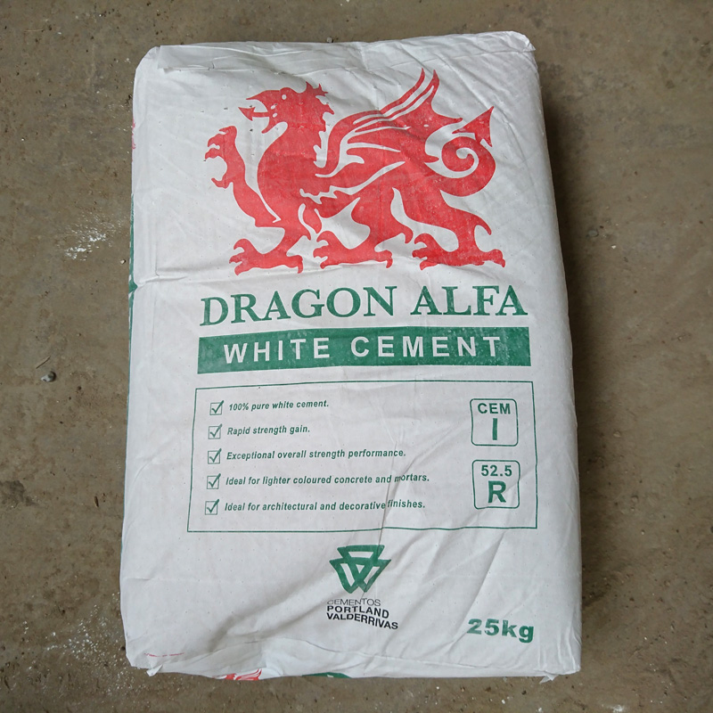 A 25kg Bag of Premium White Cement on a concrete floor displays a red dragon logo, highlighting its rapid strength gain and suitability for decorative finishes.