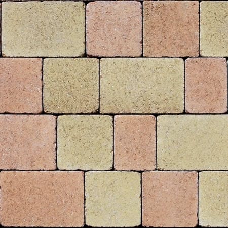 Close-up of a brick wall featuring Barleystone Kingspave Cobble Oak with alternating rectangular and square bricks in beige and light brown. The textured, uneven surface mimics an oak finish for a rustic charm.