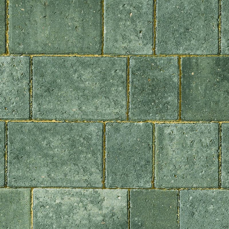 The Brett Beta Trio 60mm Silver Haze brick wall features rectangular bricks in a staggered pattern. Each brick showcases slight color variations, creating a textured look. The contrasting green mortar complements the Silver Haze hue, enhancing the overall appearance.