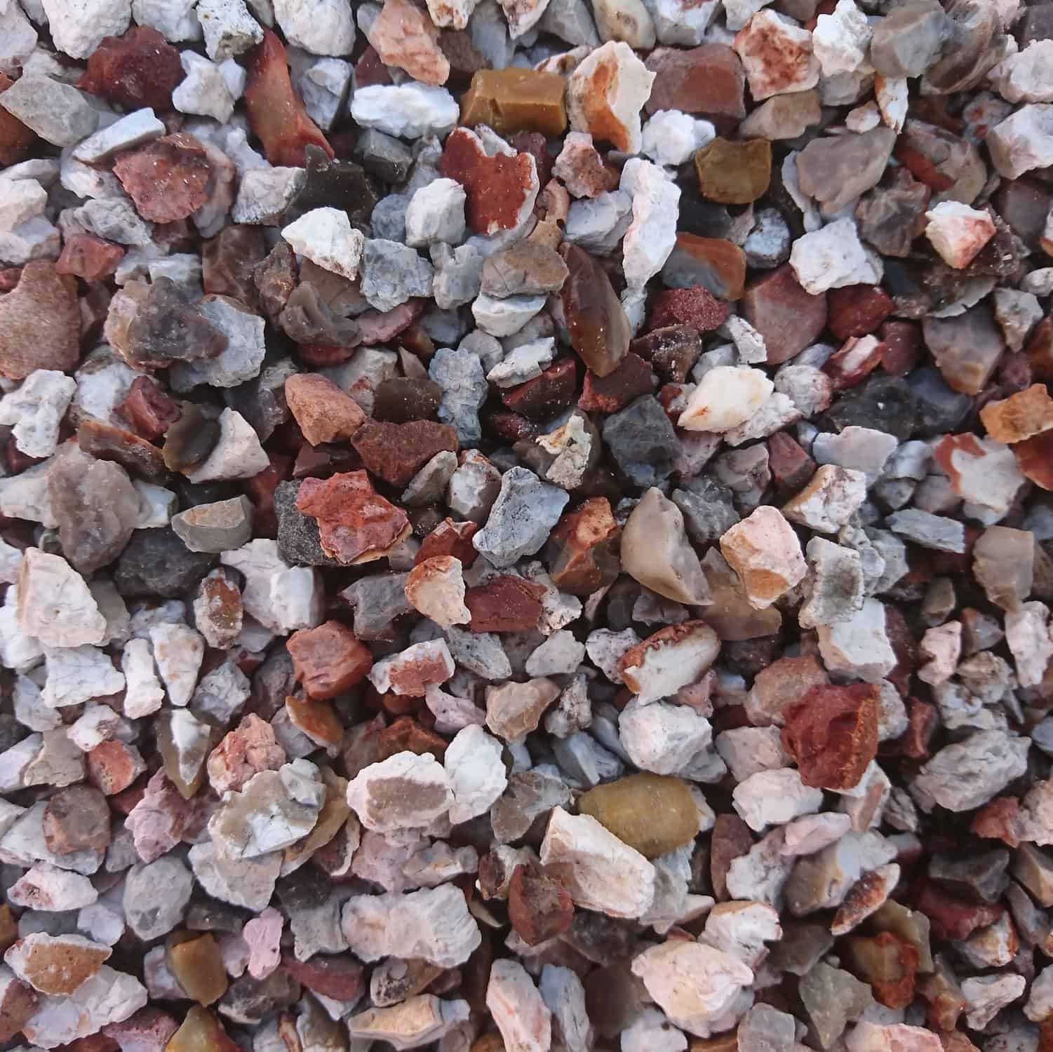 The Canterbury Spar 6-10mm stones feature a dense pile of assorted colors like white, red, brown, and gray. Their irregular shapes make them perfect for bagged garden projects.