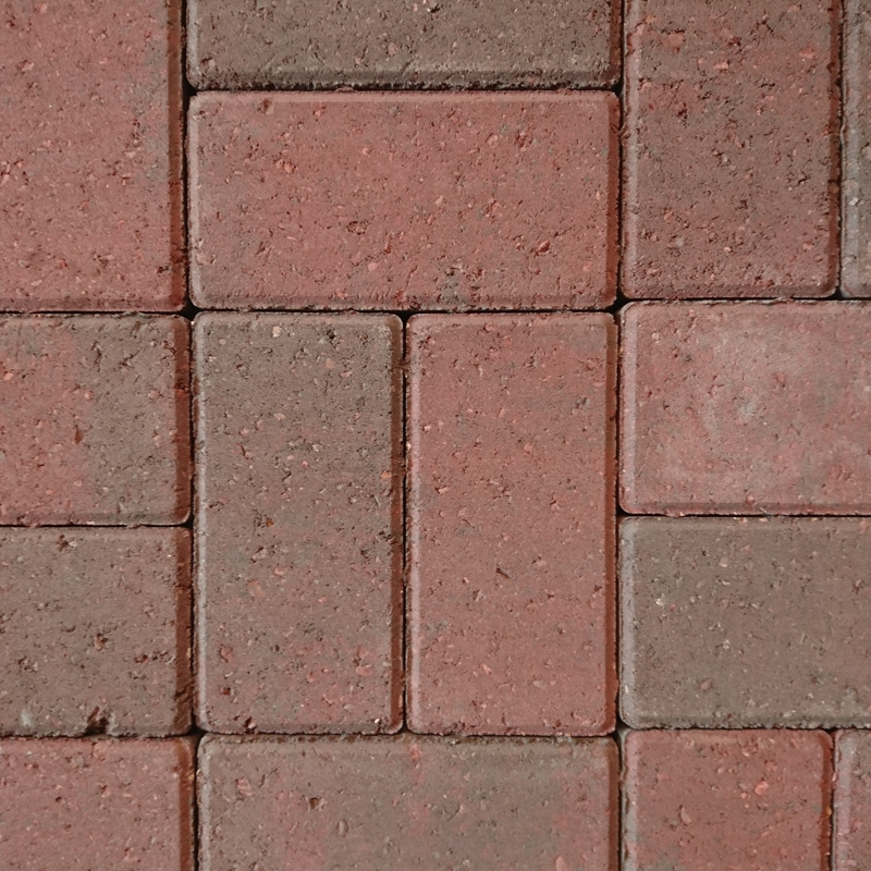 Close-up of Breedon 50mm Drive Brindle paving stones, featuring a reddish and grayish pattern in a repeating sequence. The surface is ideal for driveways with slight texture variations and small gaps between the stones.