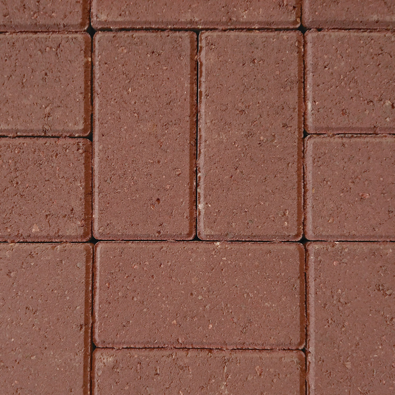 Close-up of a grid pattern featuring Breedon 50mm Drive Red bricks. These red rectangular bricks are tightly arranged, showcasing a rough texture and consistent color that reflects Breedon's meticulous craftsmanship and design.