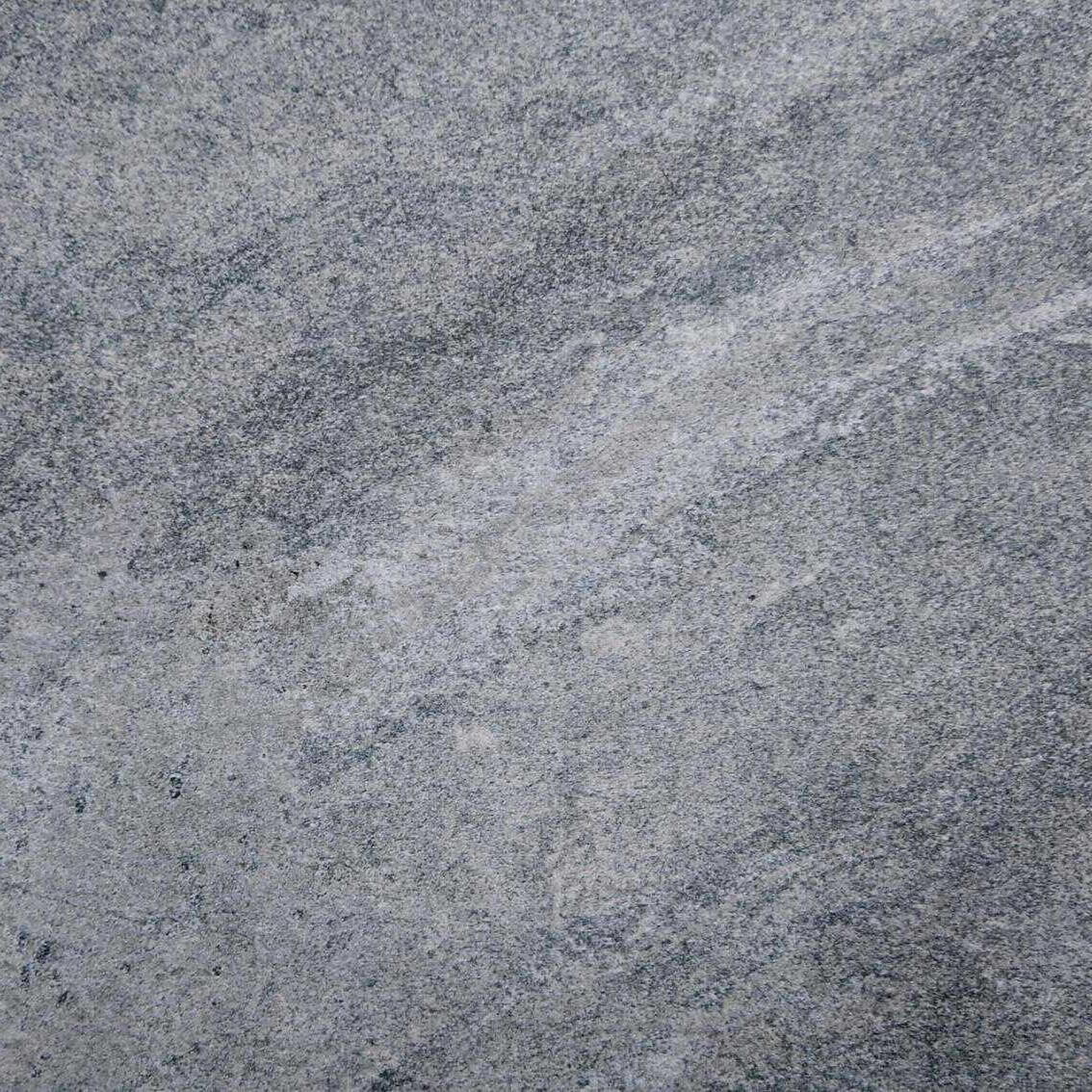 A close-up of Premier Mercury Silver Grey Porcelain 900x600x20mm reveals a smooth surface with subtle texture and color variations, fine grains, and faint wavy patterns. Its natural appearance boasts uniform shades of light and dark gray.