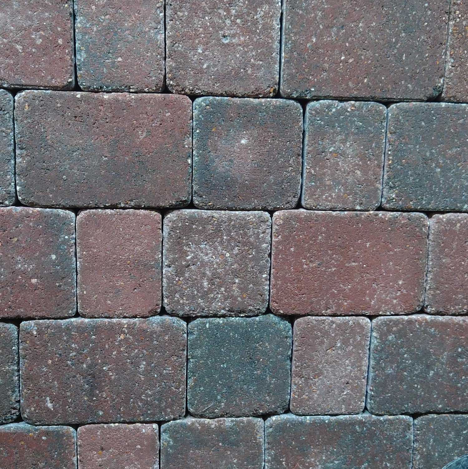 Close-up of Breedon 50mm Norfolk Rumbled Brindle Setts pattern using a 50mm lens. The brown and gray pavers are evenly arranged in a staggered formation, displaying a textured surface with slight color variations and wear.