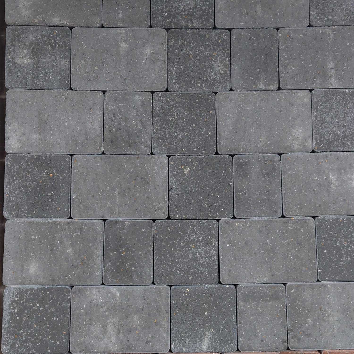 A pattern of Breedon 50mm Suffolk Smooth Charcoal Setts, featuring a slightly speckled texture, is arranged in a staggered overlapping design reminiscent of elegant style.