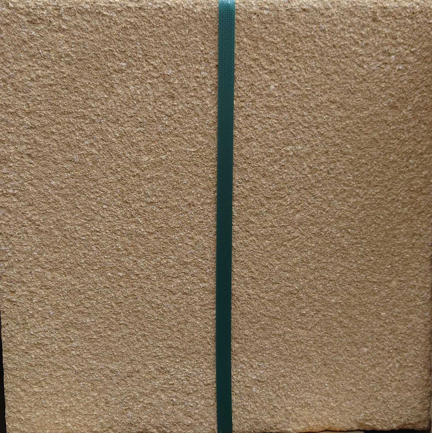 An Oakdale Centurion Textured Buff Slab (450 x 450), stands with a rough surface. A green strap runs vertically, contrasting against the beige slab, while the dark background enhances its texture and vibrant strap.