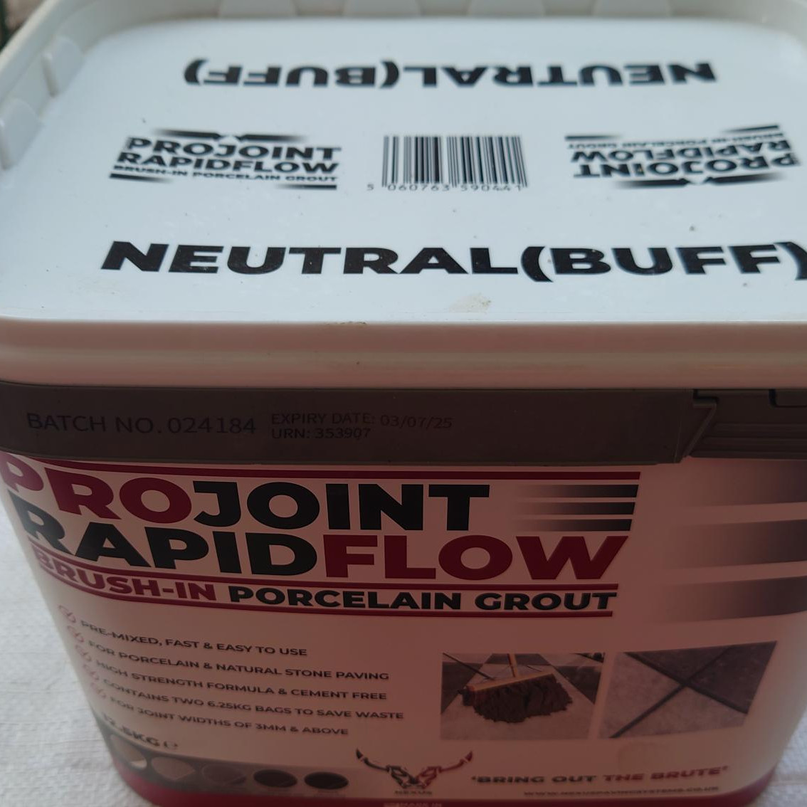 The ProJoint Rapidflow PORCELAIN Grout (Buff) container, batch 024184, expires on 18/07/25 and includes imagery and text with grout application instructions.