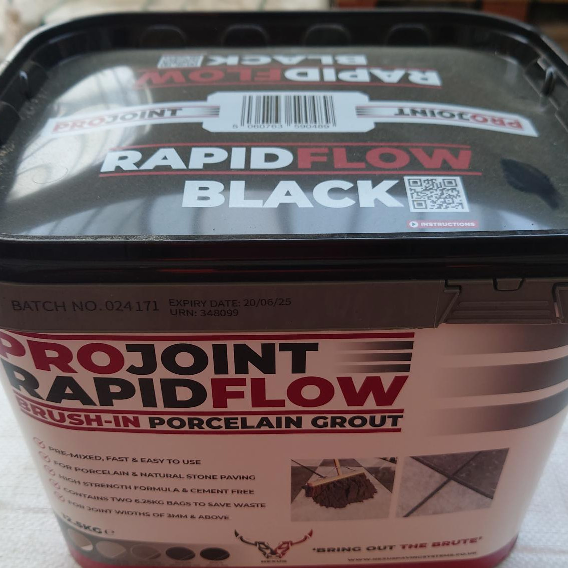 A ProJoint Rapidflow Porcelain Grout (Black) rectangular container with a partially open lid displays application images and features on its label. The batch number and expiry date near the lid highlight this ProJoint product's quality.